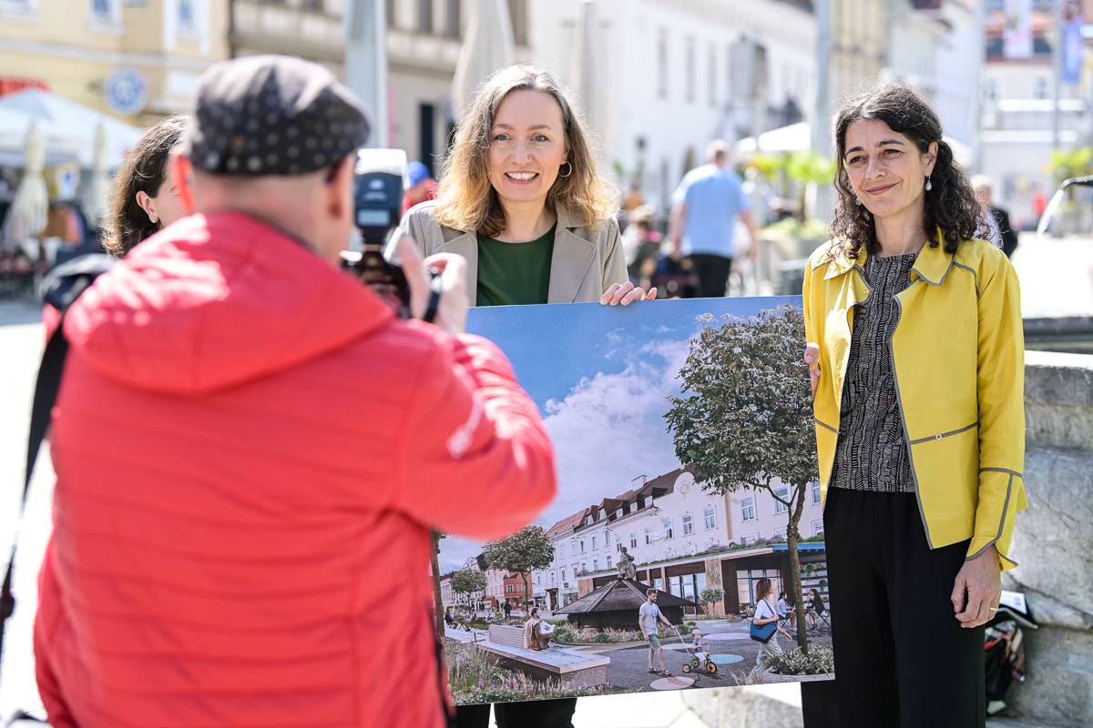 Zu sehen sind: Mehrere Personen mit einer Visualisierung des Hauptplatzes Leoben