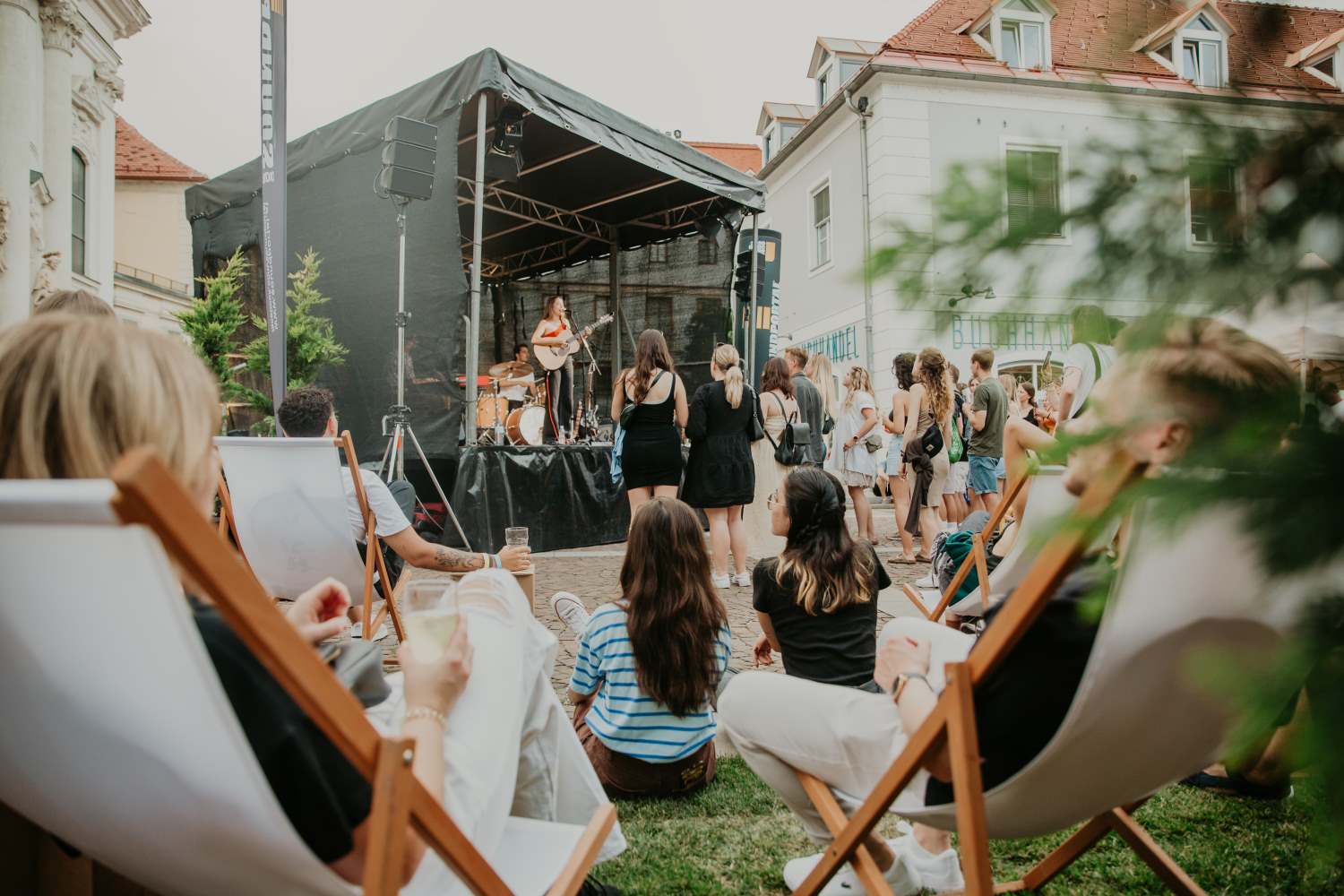 Zu sehen sind: Menschen vor einer Festivalbühne