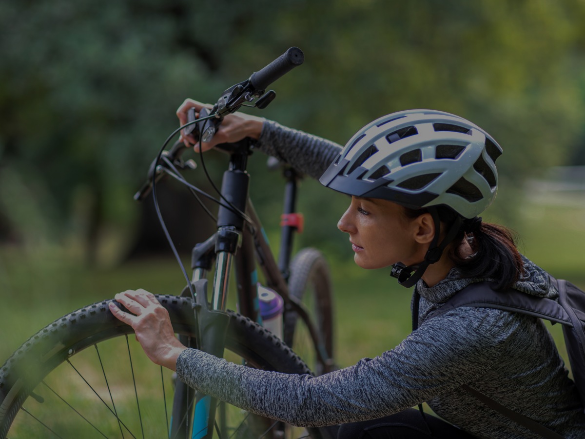 Zu sehen ist: eine Person mit einem Fahrradhelm und einem Fahrrad