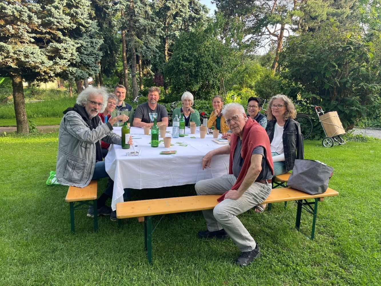 Zu sehen ist: eine Gruppe von Menschen rund um einen Tisch