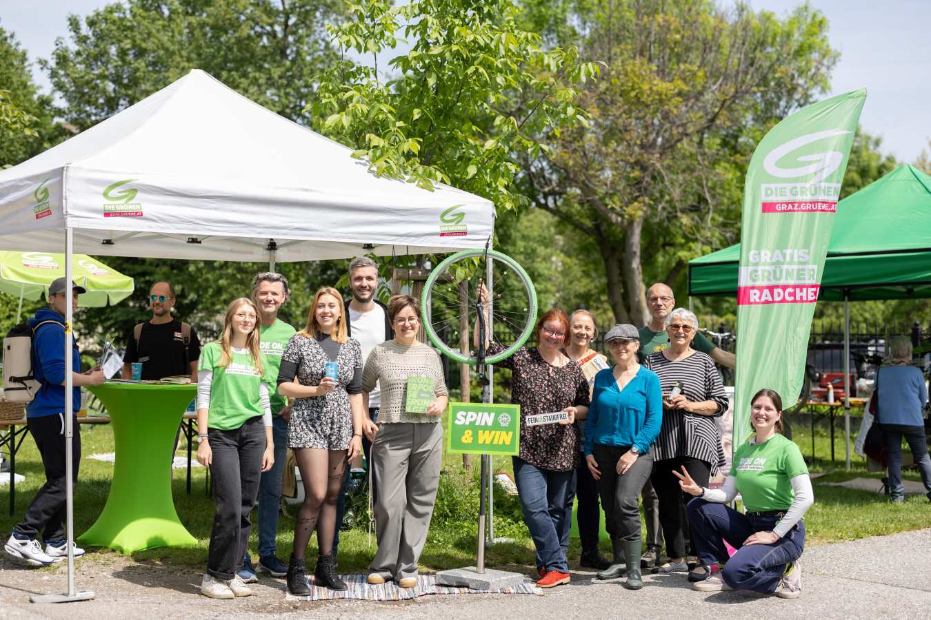 Zu sehen ist: eine Gruppe von Menschen vor einem grünen Radcheck